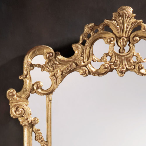 Neoclassic style carved wood decorative mirror with leaf scrolls design. Mirror finished in antiqued gold leaf. This mirror is hand-crafted in Italy