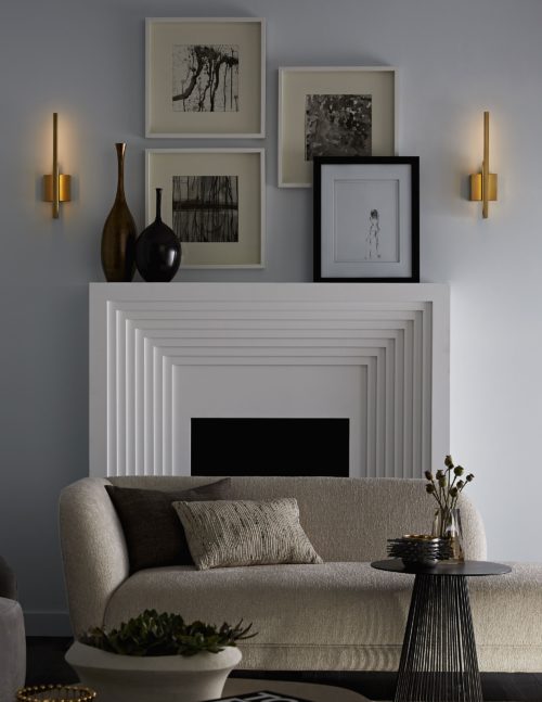 Super modern and luxurious living room and modern fireplace featuring luxe antique brass sconce. Scones create an indirect light that adds depth with modern luxury.