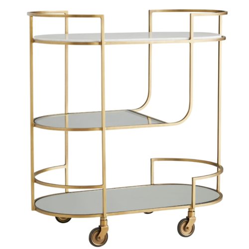 Crafted with an iron frame in an antique brass finish, each of the three tiers of this capsule-shaped bar cart features a different element. The top tier is inset with solid white marble, the second tier is inset with clear glass and the third tier is inset with mirrored glass
