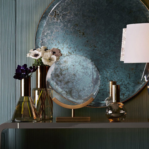 Elegant interior setting with round antiqued glass mirror and contemporary accessories; interior design ideas; decorating inspiration