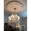 Installation of ceiling medallion with chandelier, flower and scroll design