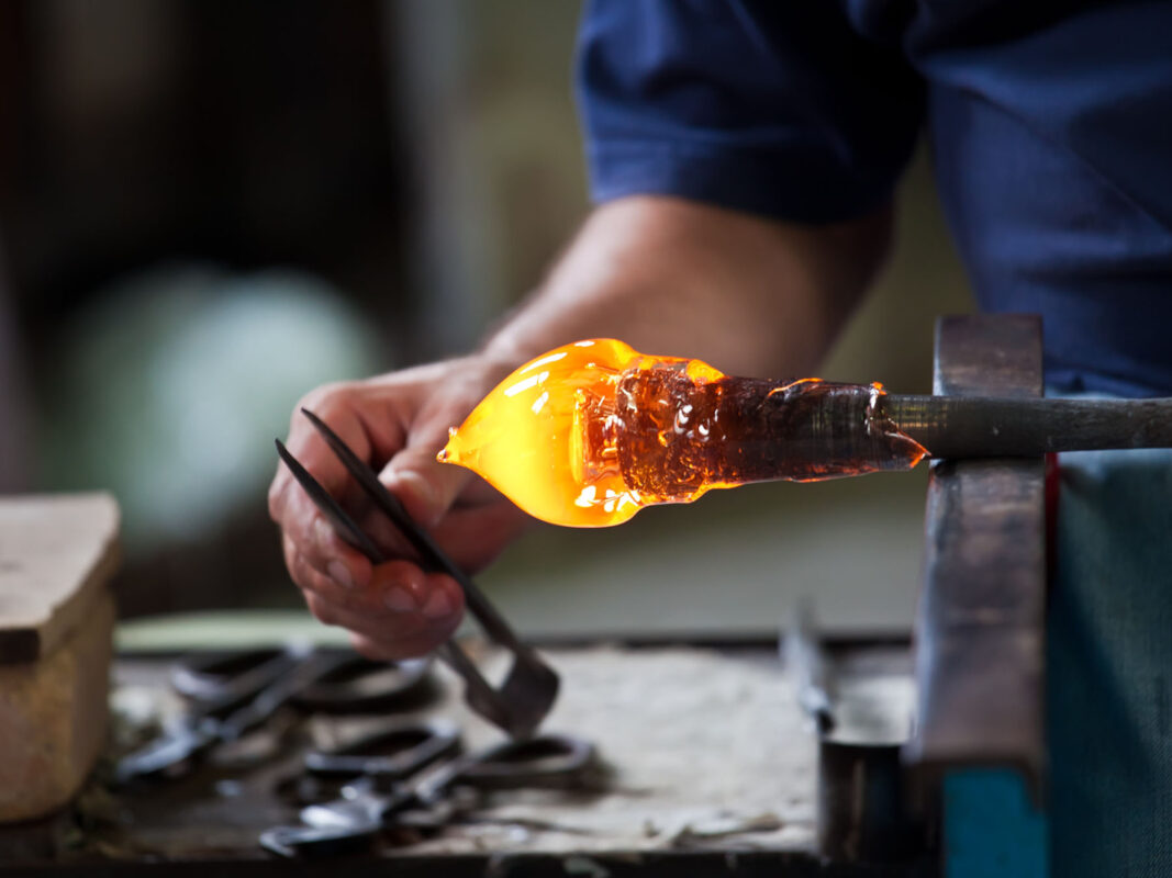 Artisan craft maker forming hot glass into luxurious design